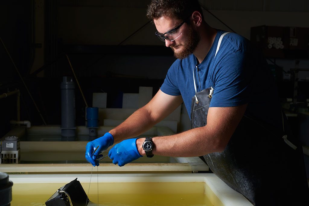 Worker performing passivation at Quality Fabricators